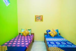 Postel nebo postele na pokoji v ubytování OYO 2440 Wallet Family Residence Syariah