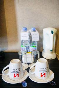 a table topped with plates and cups and bottles of milk at Swiss-Belhotel Kendari in Kendari