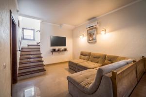 a living room with a couch and a tv at Villa Bugaz in Zatoka