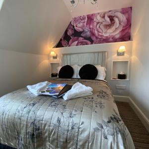 a bedroom with a bed with a flower painting on the wall at Dene House Guest House in Bowness-on-Windermere