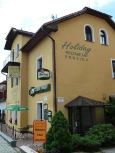 a building with a sign for a restaurant at Penzion Holiday in Mariánské Lázně