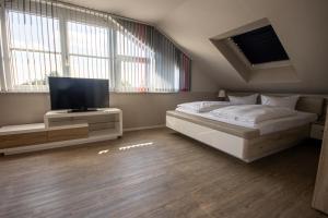 1 dormitorio con 1 cama y TV de pantalla plana en Check Inn Hotel Merseburg, en Merseburgo