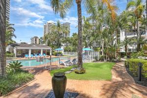 a resort with a swimming pool and palm trees at Chidori Court in Gold Coast