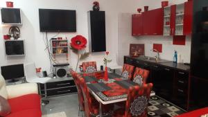 ein Esszimmer mit einem Tisch und roten Stühlen in der Unterkunft La Stanci in Crăciunești