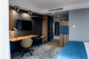 a bedroom with a bed and a desk and a television at Park Hotel City in Surgut