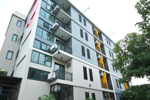 un edificio de apartamentos con balcones y árboles en Sleep Hotel Bangkok en Bangkok