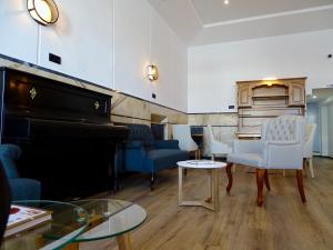 a living room with a piano and chairs at Poveira Hotel in Porto