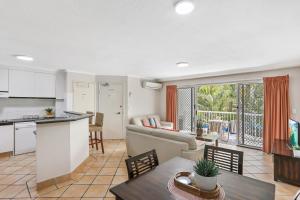 cocina abierta y sala de estar con mesa y sillas en Chidori Court, en Gold Coast