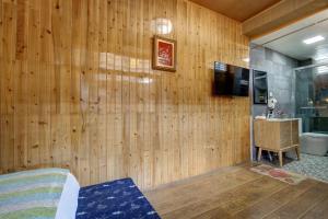 a room with a wooden paneled wall with a television at Dream Bay in Tengchong