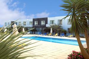 ein Hotel mit einem Pool vor einem Gebäude in der Unterkunft Hotel Vale Do Navio in Capelas