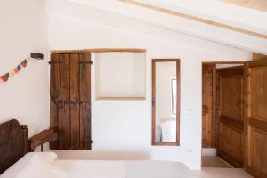 um quarto com paredes brancas e portas de madeira em Can Estaràs em Fornalutx