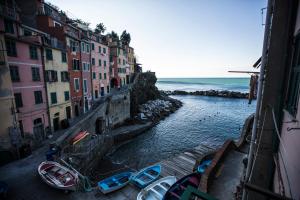 een groep boten in een rivier met gebouwen bij Allo Scalo Dei Mille in Riomaggiore