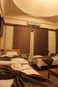 a room with three beds and a fan on the wall at Duran Aga Konagi in Şahinbey