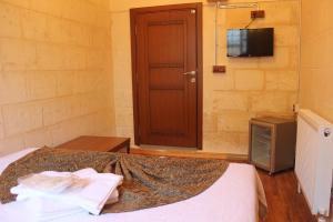 a bedroom with a bed with a tv and a door at Duran Aga Konagi in Şahinbey