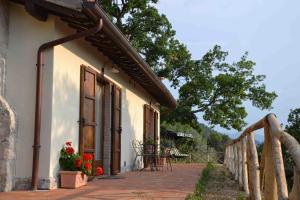 a building with a porch with flowers on it at Agriturismo Istrice Innamorato in Campello sul Clitunno