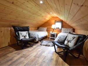a bedroom with a bed and a couch in a room at Loch Aweside Forest Cabins in Dallavich