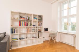 een witte boekenplank in een woonkamer met een raam bij Parkview Alsergrund in Wenen