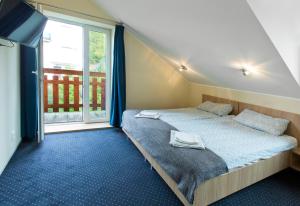 a bedroom with two beds and a large window at Olkuska 107 A in Gdynia
