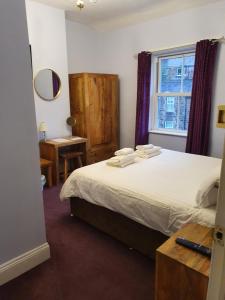 a bedroom with a bed and a window and a desk at The Camberley in Harrogate
