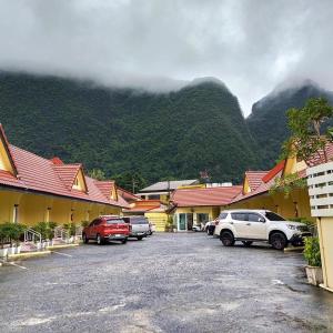 a parking lot with cars parked in front of a mountain at Rachawadee House in Phangnga