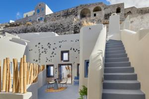 Un escalier mène à un bâtiment avec un château. dans l'établissement Luna Santorini Suites, à Pyrgos