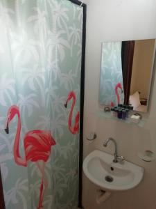 a bathroom with a sink and a shower curtain with flamingos at Green House Boğaziçi-Dodo House in Bogazici