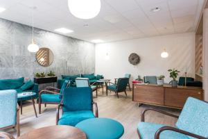ein Wartezimmer mit blauen Stühlen und Tischen in der Unterkunft B&B HOTEL Rothrist Olten in Rothrist
