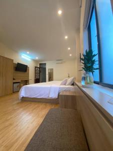 a bedroom with a large bed and a large window at An Thai Homestay Hue in Hue