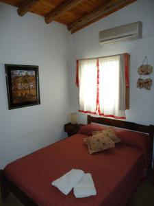 a bedroom with a red bed with two towels on it at Las Cuatro Estaciones in San Rafael