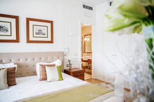 a bedroom with a bed with white sheets and pillows at Grand Hotel Terme Sirmione in Sirmione