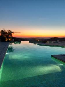 uma piscina com um pôr-do-sol ao fundo em Fattoria La Pieve em Stribugliano