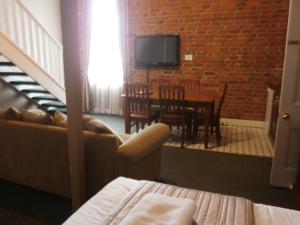 a living room with a couch and a table and chairs at Central Springs Inn in Daylesford