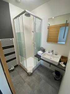 uma casa de banho com uma cabina de duche em vidro e um lavatório. em Fatty George em Viena