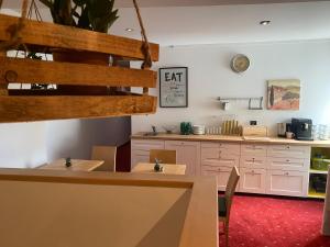eine Küche mit weißen Schränken sowie einem Tisch und Stühlen in der Unterkunft Fatty George in Wien