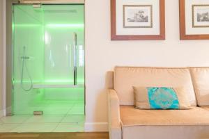 a glass shower in a bathroom with a couch at Grand Hotel Terme Sirmione in Sirmione