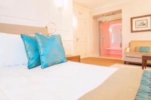 una camera da letto con letto e cuscini blu di Grand Hotel Terme a Sirmione