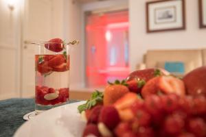 a vase filled with fruit next to a plate of fruit at Grand Hotel Terme in Sirmione