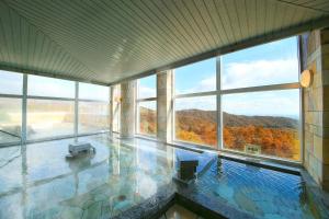 a large building with a swimming pool with windows at TAOYA Nikko Kirifuri in Nikko