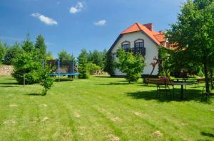 a house with a picnic table and a playground at Żabie Oko in Kruklanki