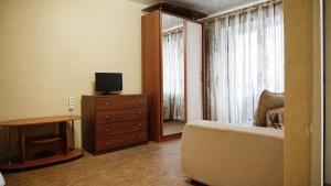 a bedroom with a bed and a dresser and a window at Doba In Ua Hoholya Apartments in Dnipro