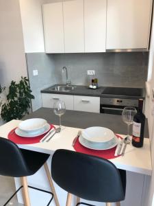 eine Küche mit einem Tisch mit 2 Tellern und Weingläsern in der Unterkunft Sweet Dreams - Studio Apartment in Dubrovnik