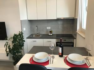 a kitchen with a table with two plates and a bottle of wine at Sweet Dreams - Studio Apartment in Dubrovnik +15 photos