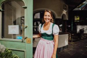 Una donna in piedi davanti a una porta di Hotel Pass Lueg a Golling an der Salzach