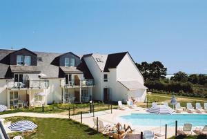 une grande maison avec une piscine en face de celle-ci dans l'établissement Résidence Pierre & Vacances La Voile d'Or, à l'Île-aux-Moines