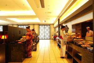 a group of people standing in a kitchen preparing food at Ijika Daiichi Hotel Kagura in Toba