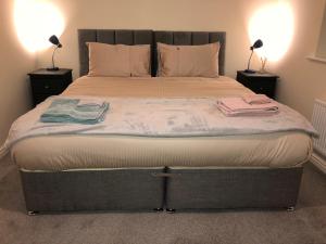 Entire Two Bed Coach House Super King Beds Turn into singles في Countess Wear: غرفة نوم بسرير كبير عليها منشفتين