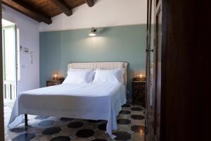 een slaapkamer met een wit bed en 2 nachtkastjes bij Case d'Oriente in Modica