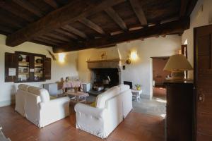 a living room with white chairs and a fireplace at Locanda Del Viandante B&B in Anghiari