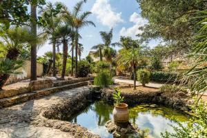 una piscina de agua en un patio con palmeras en Solemar Sicilia - Villa Anastasia, en Ficarazzi