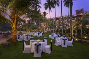 a banquet area with tables and chairs and palm trees at Lazy Lagoon, Baga A Lemon Tree Resort, Goa in Baga